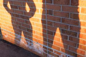Silhouette of man and woman against brick wall